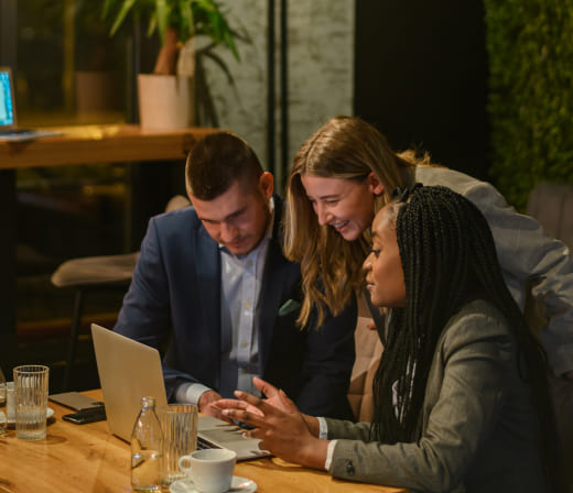 cheerful-work-colleagues-working-on-a-laptop-while-2023-11-27-05-31-02-utc-1.jpg